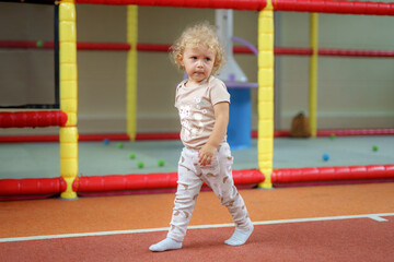 Child walking on a colorful indoor playground with soft play equipment in a fun and safe environment