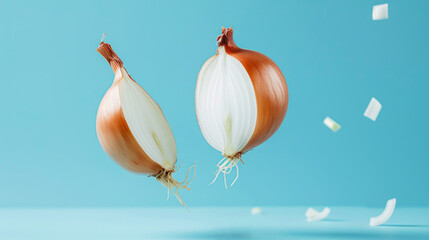 Halved onions in freefall with rings showing clearly, set against a light blue soft background.