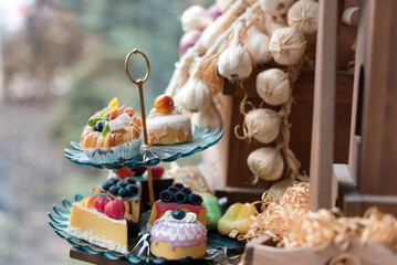 Elegant display of assorted desserts on a tiered tray with natural decor.