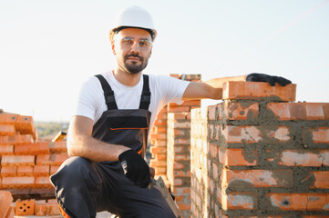 Construction worker in uniform and safety equipment have job on building. Industrial theme