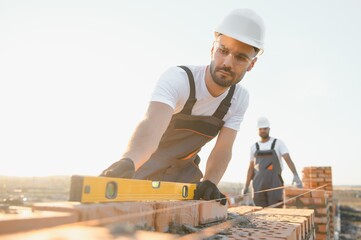 Construction worker man in work clothes and a construction helmet. Portrait of positive male...