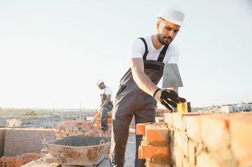 Construction worker in uniform and safety equipment have job on building. Industrial theme