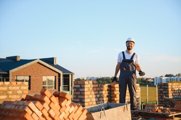 Construction worker in uniform and safety equipment have job on building