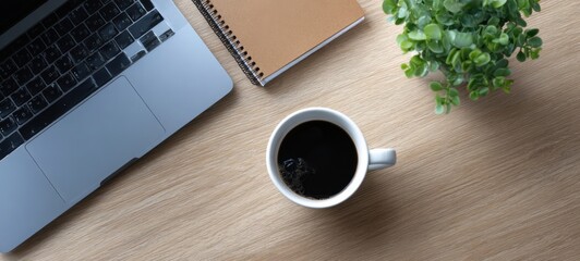 The cozy workspace featuring a coffee cup and laptop arrangement.