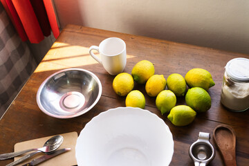 Top view of all ingredients ready for baking a lemon cake on a rustic wooden table with natural...