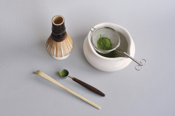 Japanese Matcha Green Tea cooking process. White Ceramic Bowl Chawan, Silver Sifter, Wooden spoon...