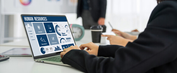 Human resources management software on computer screen helping human resources employee to manage...