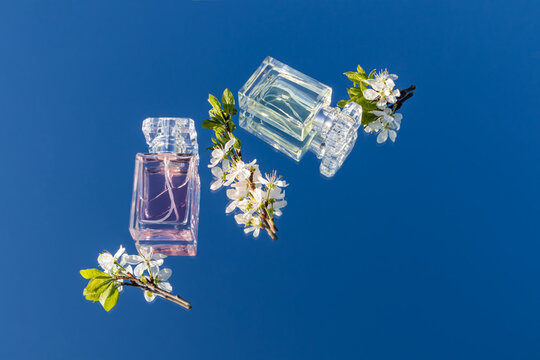 Perfume bottles with flowers and blue sky background