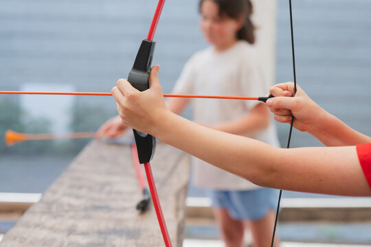 Kids in outdoor adventure with bow and arrow challenge