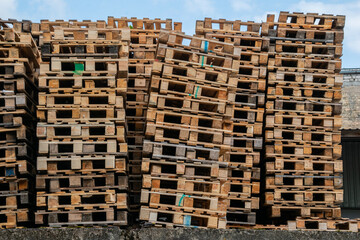 Tilted stack of used wooden pallets in storage area