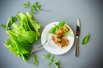 Breakfast of omelette with greens in the form of a roll on top