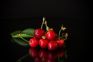 harvest of sweet red cherries on black background