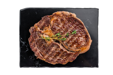 Grilled Rib eye steak with herbs and spice on marble  board, prime beef meat isolated on white...