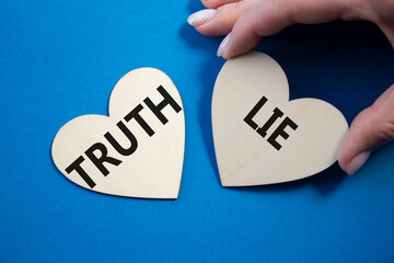 Truth or Lie symbol. Concept word Truth or Lie on wooden hearts. Businessman hand. Beautiful blue...