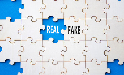 Real or Fake symbol. Concept word Real or Fake on wooden blocks. Beautiful blue background....
