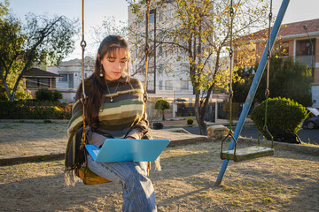 white-skinned latina woman studying on her laptop in an outdoor park in the city of la paz, bolivia...