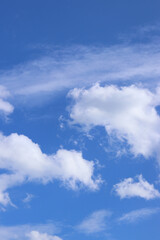 White clouds against the blue sky. Sky background. Summer. Landscape. Soft white clouds against the blue sky. Calm and serene atmosphere. White fluffy clouds