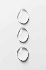 Water droplets cascade gracefully in a vertical line on a white surface, showcasing their clarity and forms