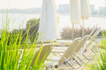 Relaxing waterfront lounge area with sun loungers and umbrellas near the river