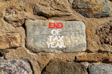 End of tax year symbol. Concept words phrase End of tax year on beautiful grey stone wall....