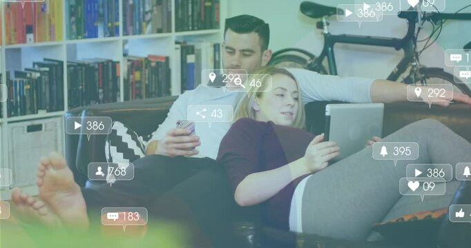 Couple on sofa scrolling devices, social media icons rising then fading back tracking engagement
