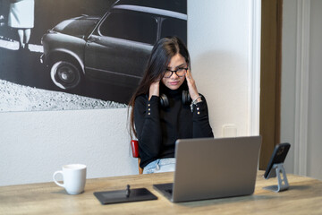 Woman experiencing mental stress while working on laptop.
