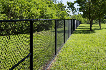 black chain link fence in park surrounded by green grass 
