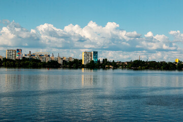 Naklejka premium Panoramic view of the left bank of the Dnieper River. Ukraine. The city of Dnieper. Reflection of sky with clouds on the water surface.