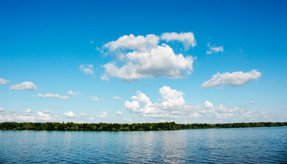 Panoramic view of the Dnieper river bank from the embankment of the city of Dnieper. Reflection of the sky with clouds on the surface of water.