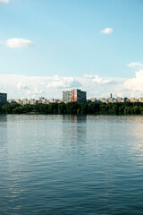 Fototapeta premium Panoramic view of the bank of the Dnieper River. Dnieper. Ukraine. Reflection of sky with clouds on water surface.