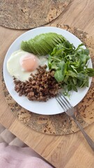 Well-balanced breakfast featuring healthy source of ptotein, fermented and fresh vegetables, salad and nuts on a plate. Top view real kitchen photo, diet and self care and love concept	