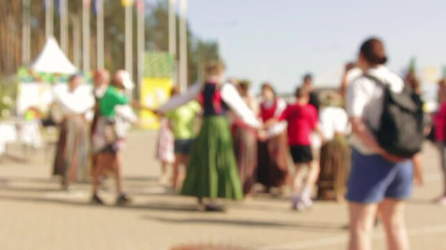Folk enthusiasts enact ring dance during daytime fair. 