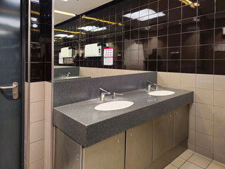 Interior of a bathroom with toilets. Design of sanitary facilities for personal care. Personal hygiene in public places. Ceramic products in everyday life.