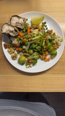 Well-balanced breakfast featuring healthy source of ptotein, fermented and fresh vegetables, salad and nuts on a plate. Top view real kitchen photo, diet and self care and love concept