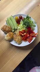 Well-balanced breakfast featuring healthy source of ptotein, fermented and fresh vegetables, salad and nuts on a plate. Top view real kitchen photo, diet and self care and love concept