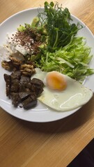 Well-balanced breakfast featuring healthy source of ptotein, fermented and fresh vegetables, salad and nuts on a plate. Top view real kitchen photo, diet and self care and love concept