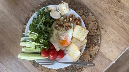 Well-balanced breakfast featuring healthy source of ptotein, fermented and fresh vegetables, salad and nuts on a plate. Top view real kitchen photo, diet and self care and love concept
