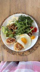 Well-balanced breakfast featuring healthy source of ptotein, fermented and fresh vegetables, salad and nuts on a plate. Top view real kitchen photo, diet and self care and love concept