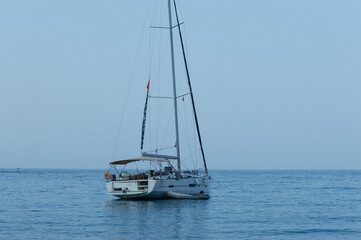 Yachting on a serene seascape at sea. A lone ship sailing on the water on a sunny summer day. Frontal view