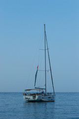 Yachting on a serene seascape at sea. A lone ship sailing on the water on a sunny summer day. Frontal view