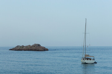 Yachting on a serene seascape at sea. A lone ship sailing on the water on a sunny summer day. Frontal view