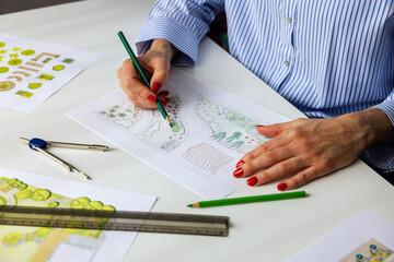 landscape architect, designer drawing ornamental garden plan in office
