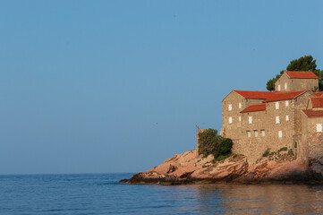 Sveti Stefan Island Hotel, stone houses of a medieval fortress village with tiled roofs on the Adriatic coast of Montenegro