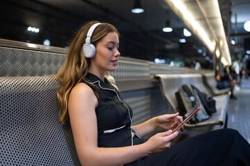 Commuter enjoying music and using smartphone on subway train