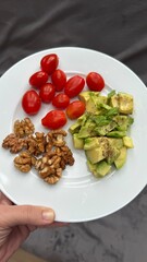 Well-balanced breakfast featuring healthy source of ptotein, fermented and fresh vegetables, salad and nuts on a plate. Top view real kitchen photo, diet and self care and love concept