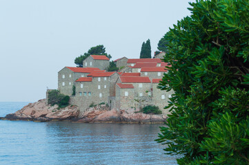 Sveti Stefan Island Hotel, stone houses of a medieval fortress village with tiled roofs on the Adriatic coast of Montenegro