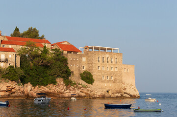 Sveti Stefan Island Hotel, stone houses of a medieval fortress village with tiled roofs on the Adriatic coast of Montenegro