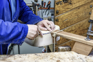 Luthier carefully installing purfling on handmade flamenco guitar body