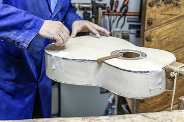 Luthier carefully installing purfling on handmade flamenco guitar body