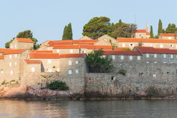Sveti Stefan Island Hotel, stone houses of a medieval fortress village with tiled roofs on the Adriatic coast of Montenegro